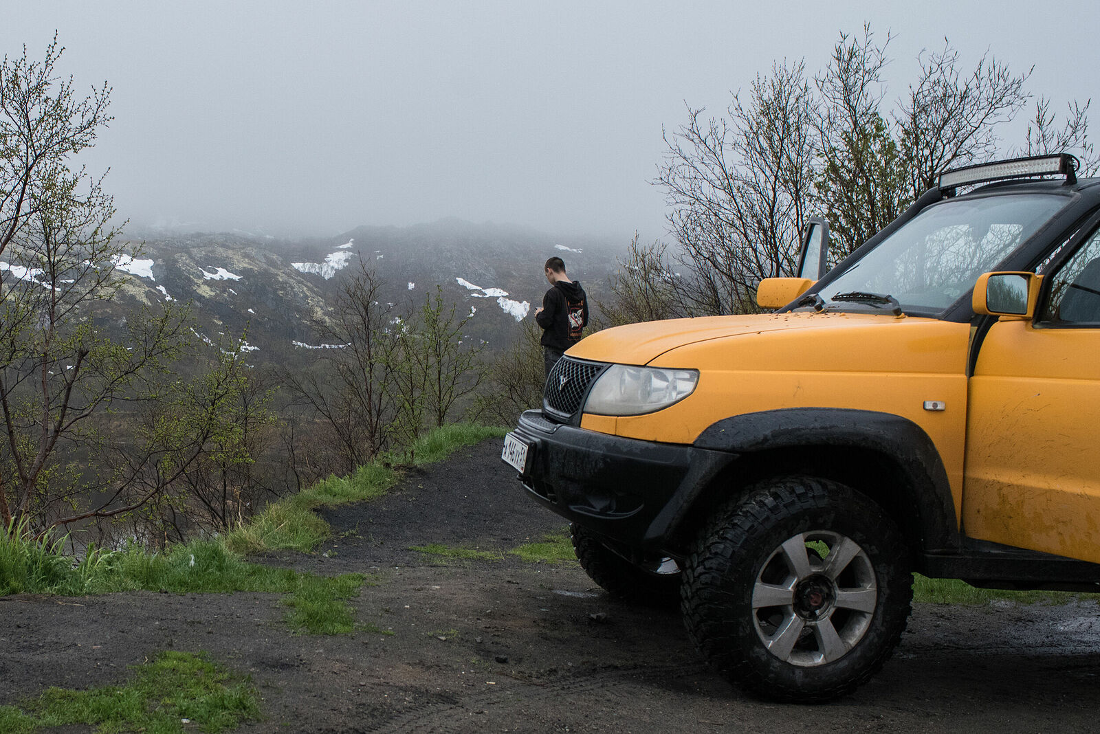 The road along the swift Titovka meanders through the taiga, where in some places the June snow from winter still remains on the slopes